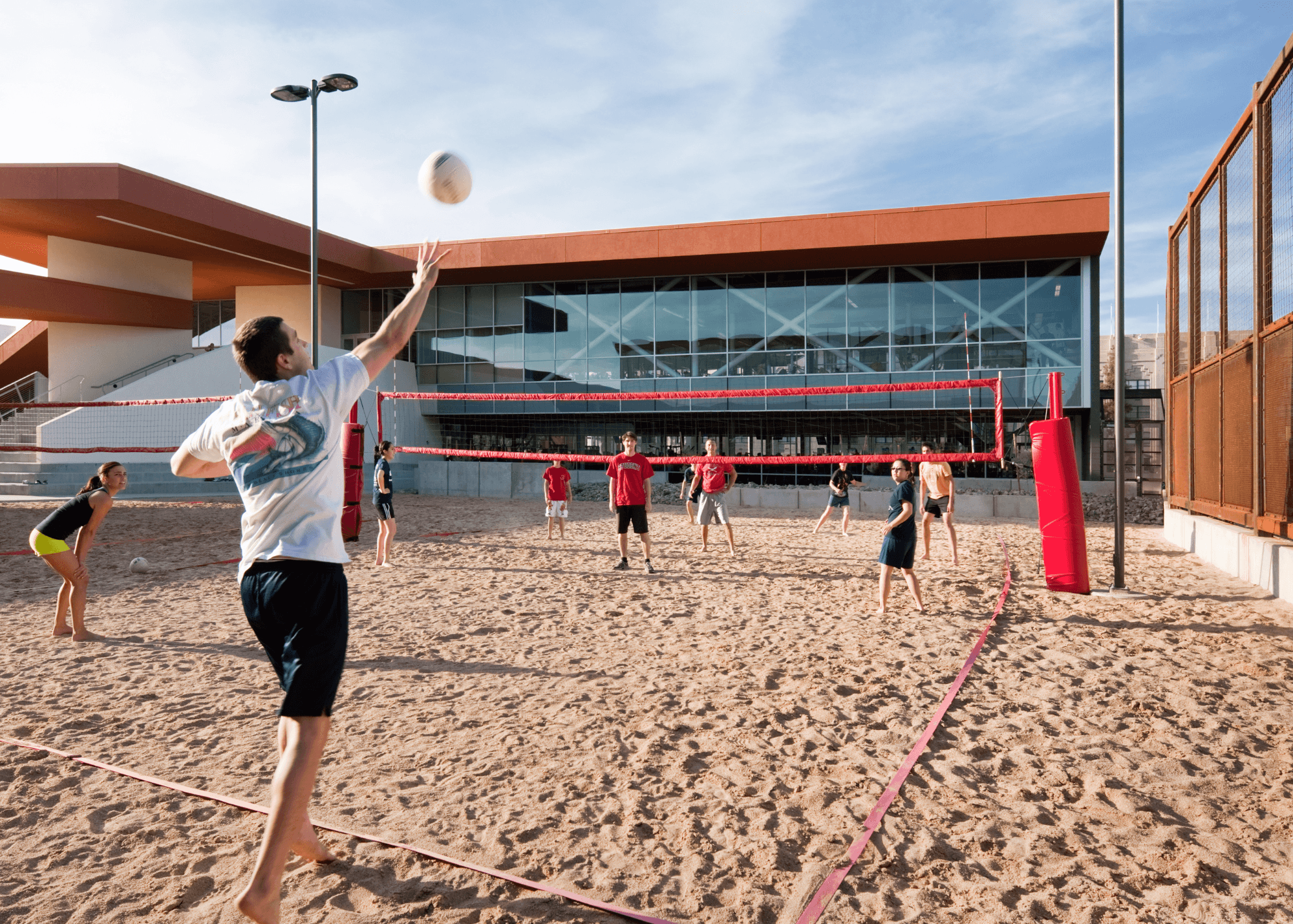 A photo of a group of students playing sand volleyball.